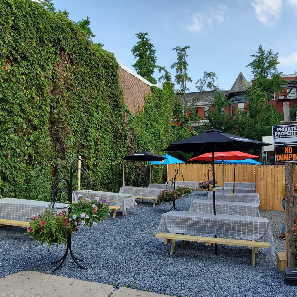 patio at Bar Charley with a stunning green wall, beautiful plants, and plenty of picnic tables to spread out