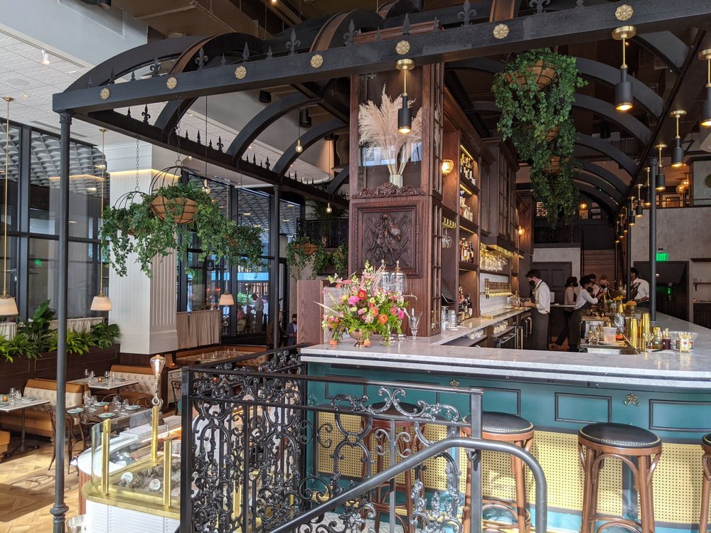 Interior of Dauphine's, featuring gorgeous iron railing, beautiful plants, and an overall authentic New Orlean's feel