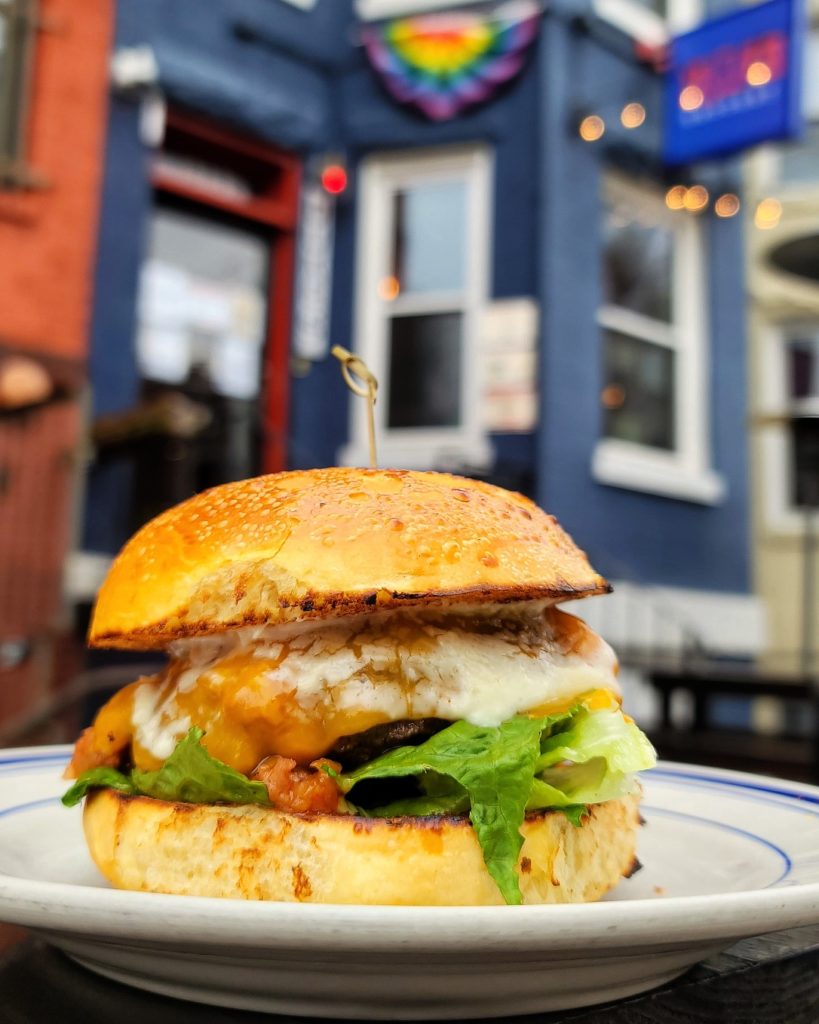 Wagyu Burger w/ Duke's jam (bacon, onion, cabernet sauvignon, tomato), cheddar, romaine, garlic aioli, brioche at Duke's Grocery