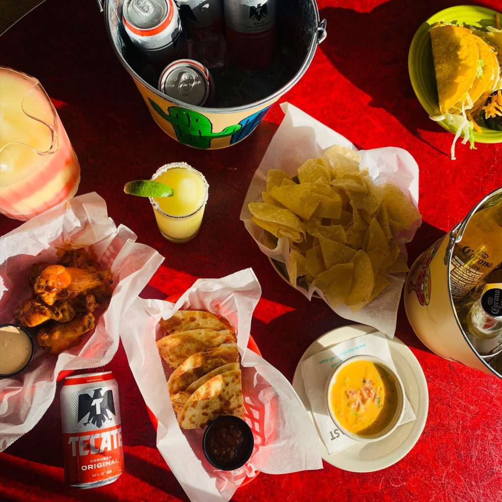Tortilla Coast happy hour items, including a frozen margarita pitcher, beer buckets, chips & queso, quesadillas, coast tacos, and buffalo wings.