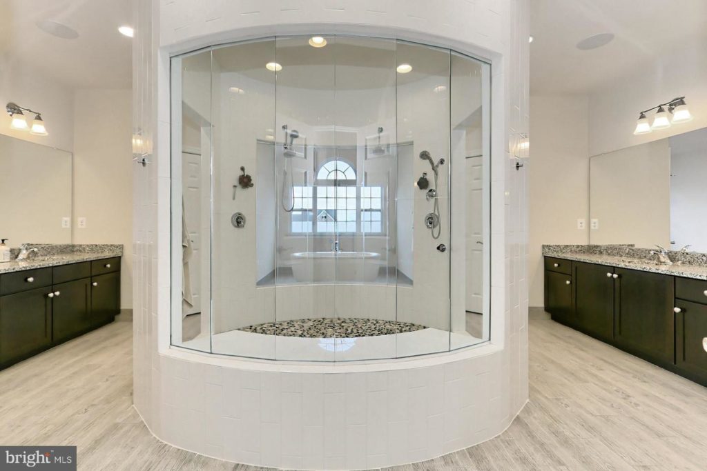 luxury bathroom with a huge walk-in shower, flanked by vanities on either side.