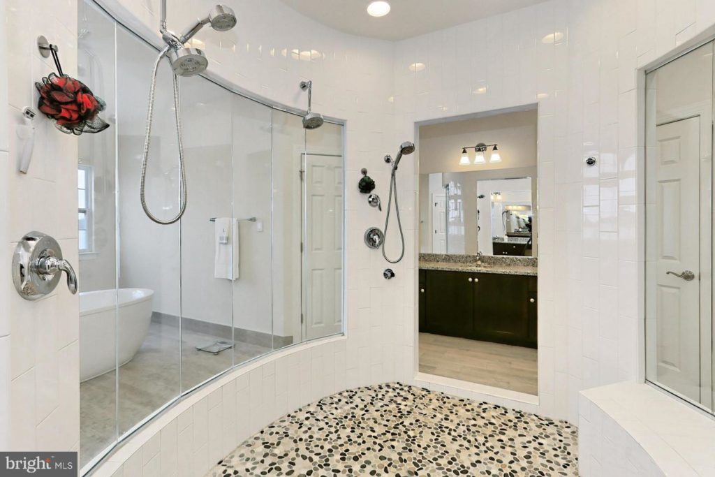 another interior shot of walk-in shower with a peak of the separate soaking tub